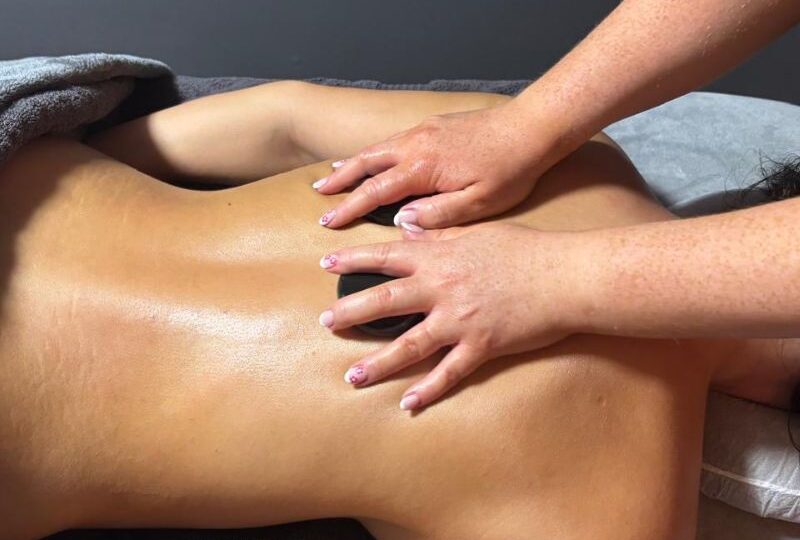 Hot stone back neck and shoulders massage in Llandudno at HUSH Therapies using heated stones